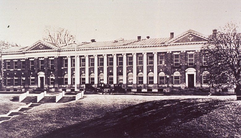 Large brick building with columns in the front and steps leading to the building