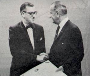 Black and white photo of two men in suits shaking hands